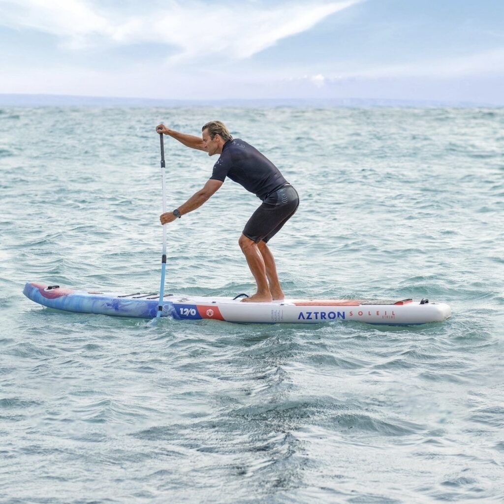 homme pagayant sur un paddle sur la mer